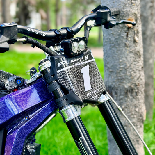 Close-up of a sparkly custom decal on a motocutz number plate on a purple emoto bike with EXT suspension, warp 9 handle bars and a baja s2 pro headlight