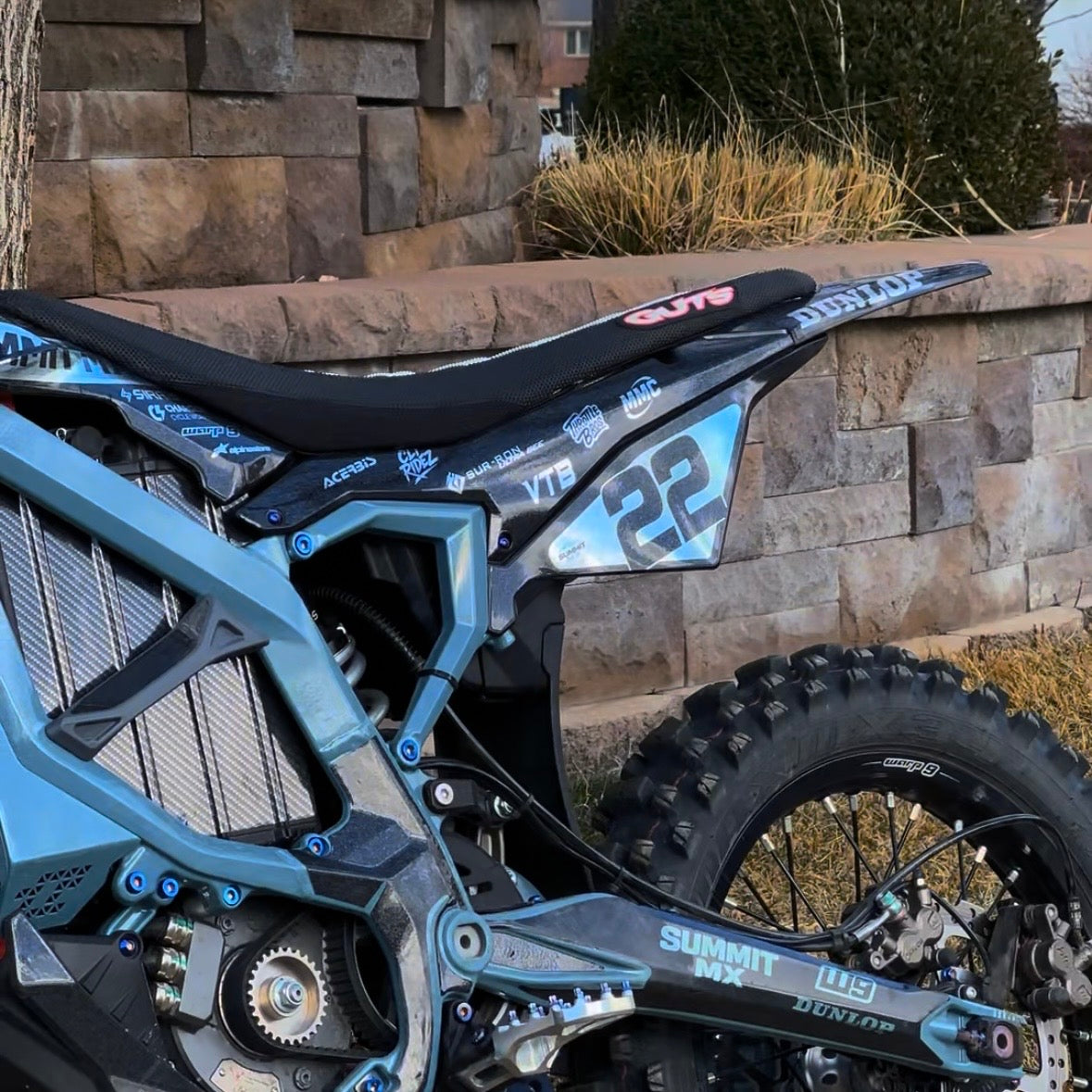 Surron Ultra Bee with Rtech graphics kit installed, number 22, teal build outdoors — Summit MX